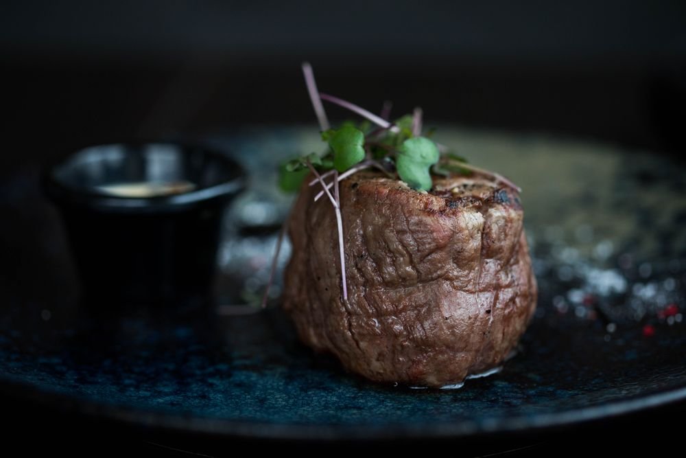 Ribeye al carbón servido sobre plato oscuro